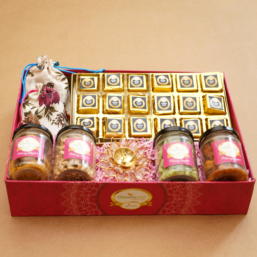 Big Pink tray of Mewa bites, jute pouches of mewa bites and anjeer bites, 2 jars of dryfruits, 2 jars of namkeen and diya
