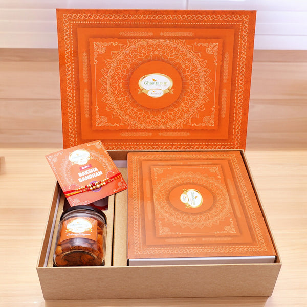 Ghasitaram Orange Hamper box with Exotic sweets, 2 rakhis, Card and a Mixed Dryfruit Jar