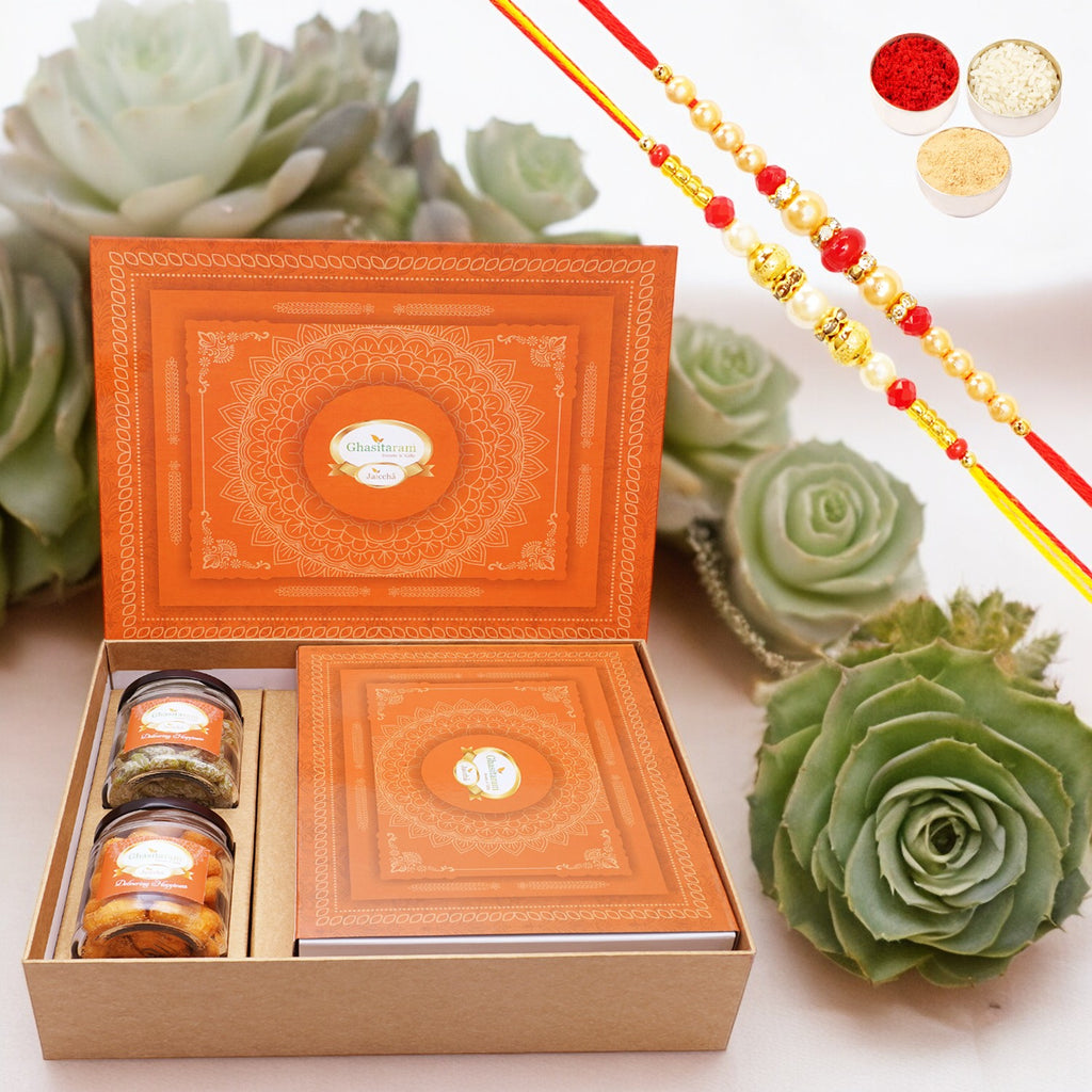 Ghasitaram Orange Hamper Box with exotic sweets, 2 rakhis, Crunchy Cashew and Paan Raisins Jar