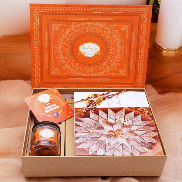 Orange Hamper Box with Kaju Katli ,  Bhaiya Bhabhi Rakhis, Card, and Mixed Dryfruit Jar