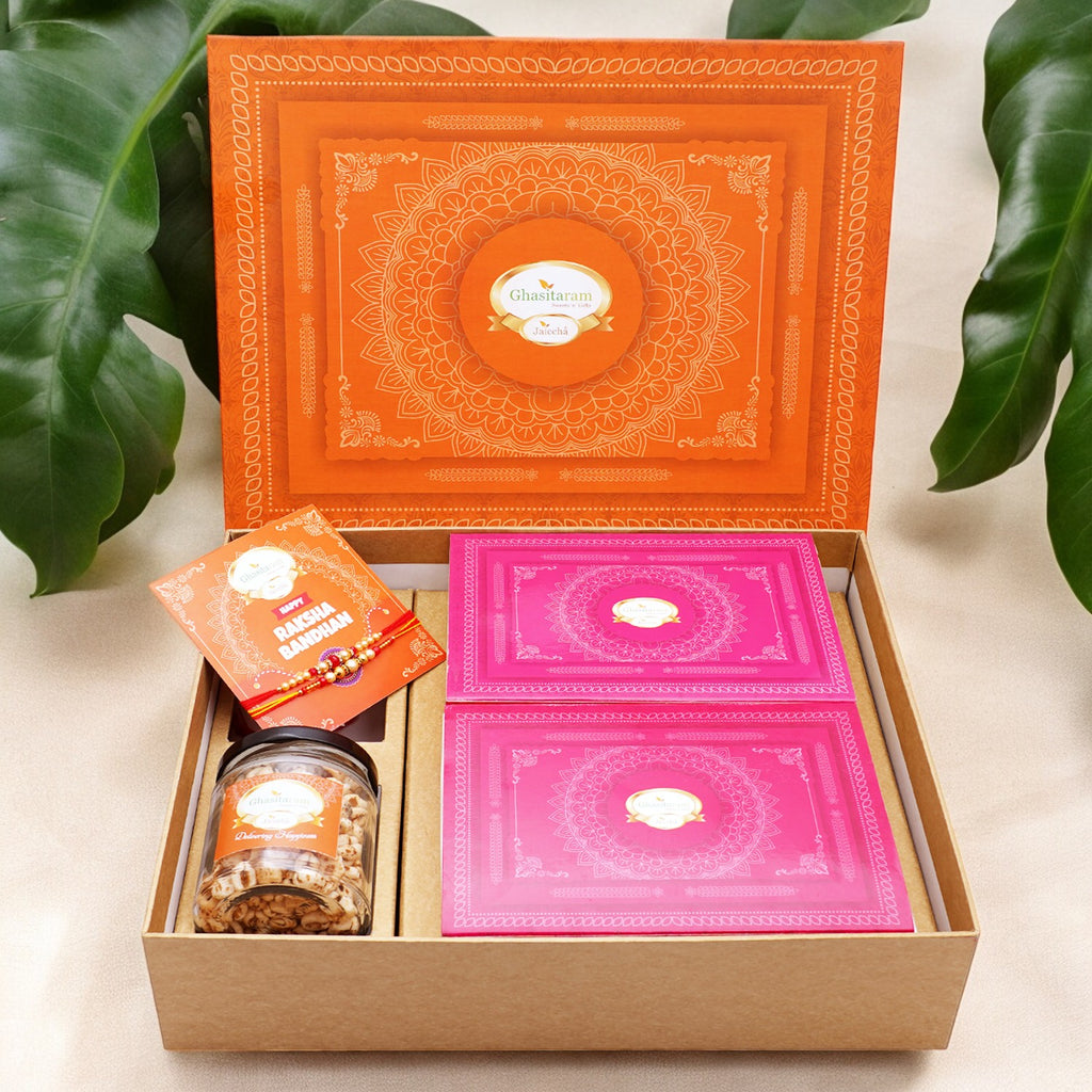 Ghasitaram Orange Hamper Box with Sugarfree Kaju Katli, Sugarfree Peda, 2 rakhis, Card, and Wheat Puffs Jar