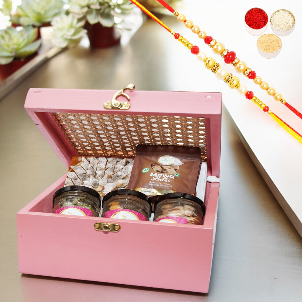 Pink Cane Rattan box with Kaju Katli, Paan Raisins, Crunchy Cashew, Pista and Mewa Bites with 2 Rakhis