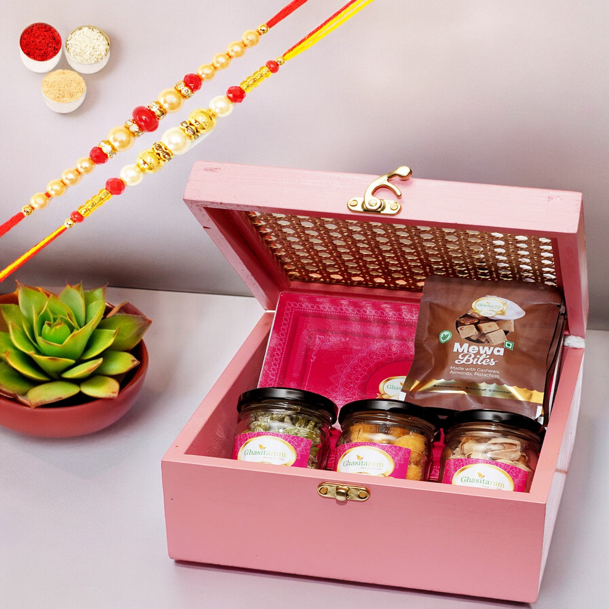 Pink Cane Rattan box with Milk Cake , Paan Raisins, Crunchy Cashew, Pista and Mewa Bites with 2 Rakhis