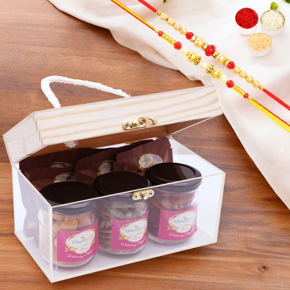 Wooden Acrylic Box of 3 jars of Crunchy Cashews, Paan Raisins, Mix Dryfruit and 5 Mewa Bites with 2 Rakhis