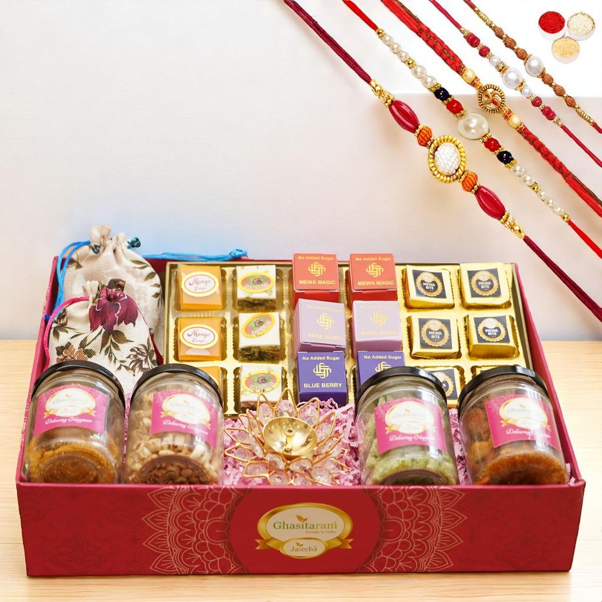 Big Pink tray of best bites, jute pouches of mewa bites and anjeer bites, 2 jars of dryfruits, 2 jars of namkeen and diya with 5 rakhis