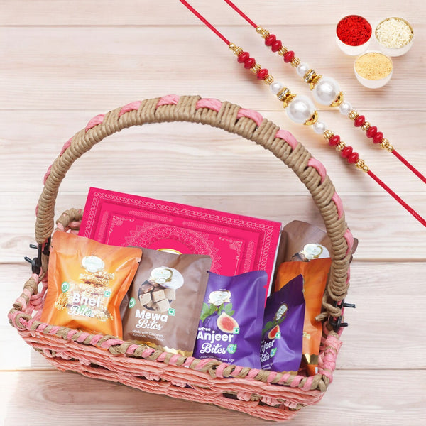 Pink basket with bites and milk cake with 2 rakhis