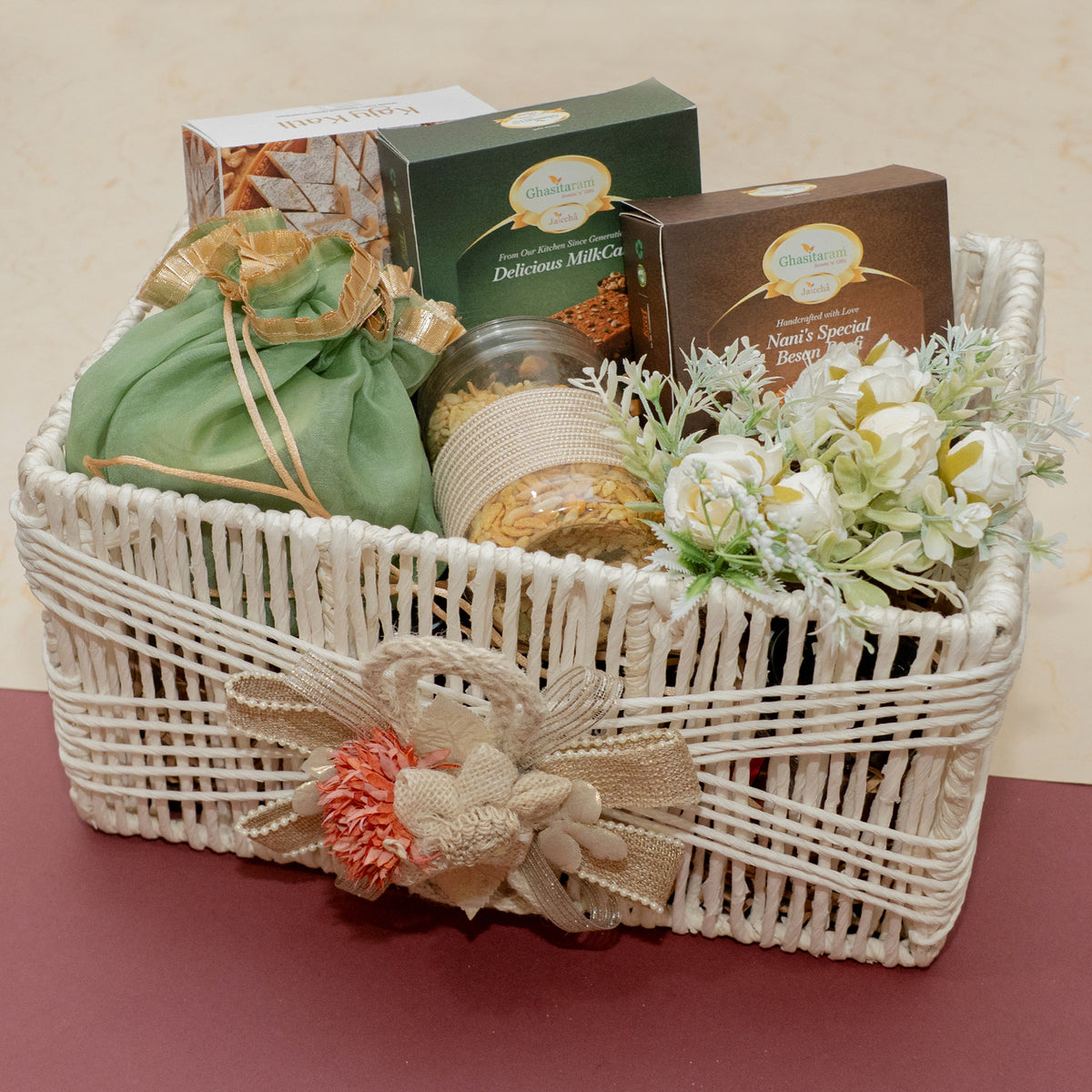 White Jute Basket of Kaju Katlis, Milk cake, Besan Barfi, Namkeen abd Dryfruit