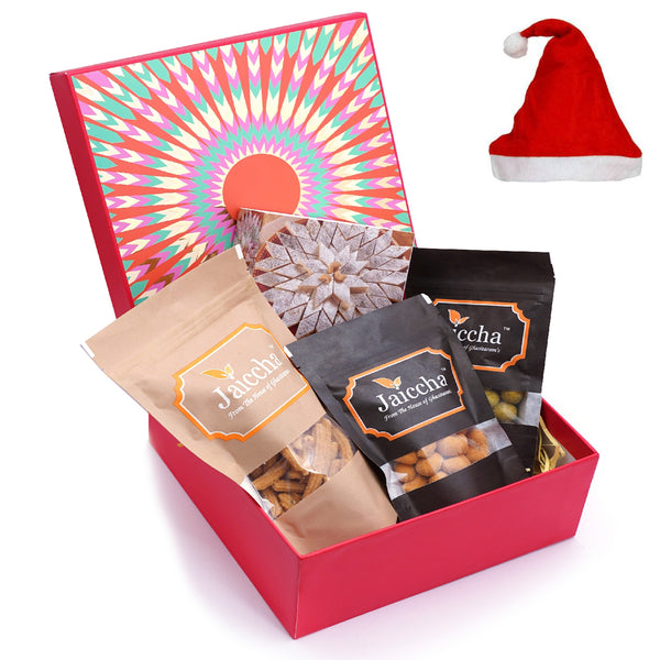 Red hamper box of Kaju Katlis, Crunchy Coated Cashews, Crunchy Coated Peanuts, Butter Chakli Sticks