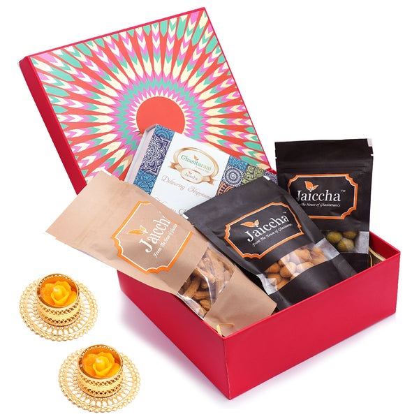 Red hamper box of Assorted bites, Crunchy Coated Cashews, Crunchy Coated Peanuts, Butter Chakli Sticks and T-lites