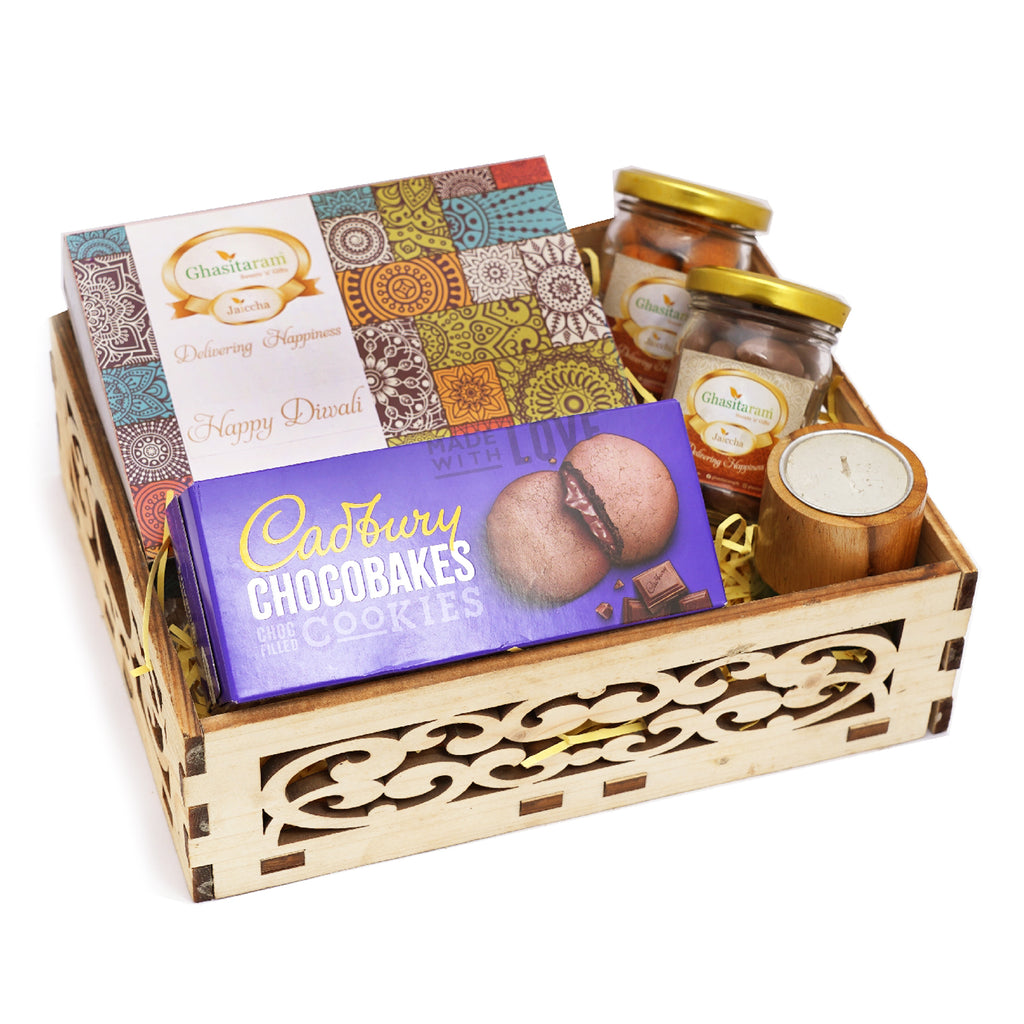 Wooden Carved Basket of Assorted Bites, Cadbury Chocobakes, Chocolate Caoted Almonds Jars, Crunchy Coated Cashews, and a Long Wooden Long T-Lite.