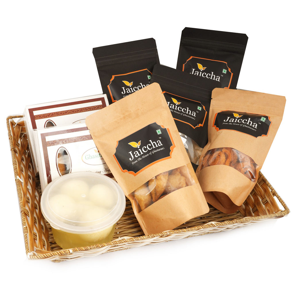 Holi Hamper-Cane Rectangle Basket of Traditional Gujiyas;  Chocolate Gujiyas; Mini Gujiya Namkeen Pouch; Farsaan samosa Pouch; Masala Chakli Pouch; Palak Chips Pouch; Coin Biscuits Pouch and a Rasgulla Pack.